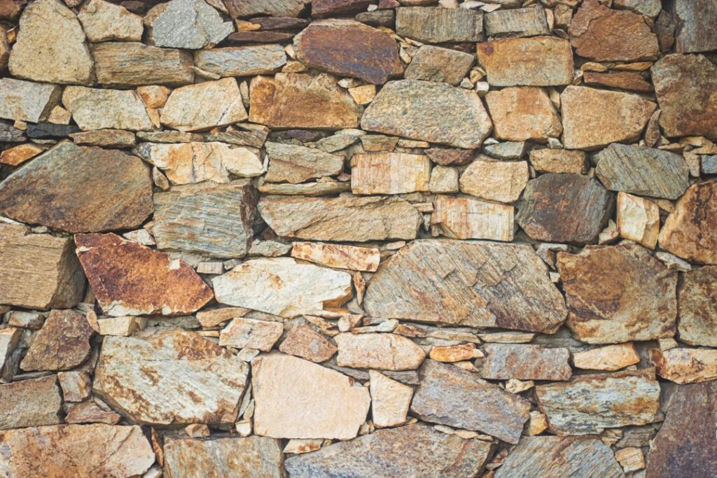 A homeowner comparing samples of natural and manufactured stone on an outdoor patio table.