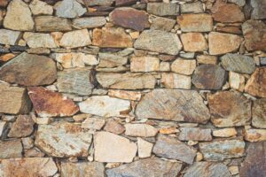 A homeowner comparing samples of natural and manufactured stone on an outdoor patio table.