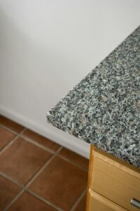 Kitchen with stone samples, wood countertop, measuring tools, and cabinets under renovation.