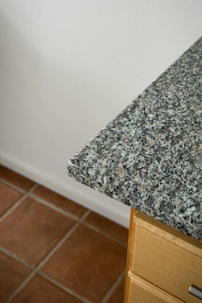 Kitchen with stone samples, wood countertop, measuring tools, and cabinets under renovation.